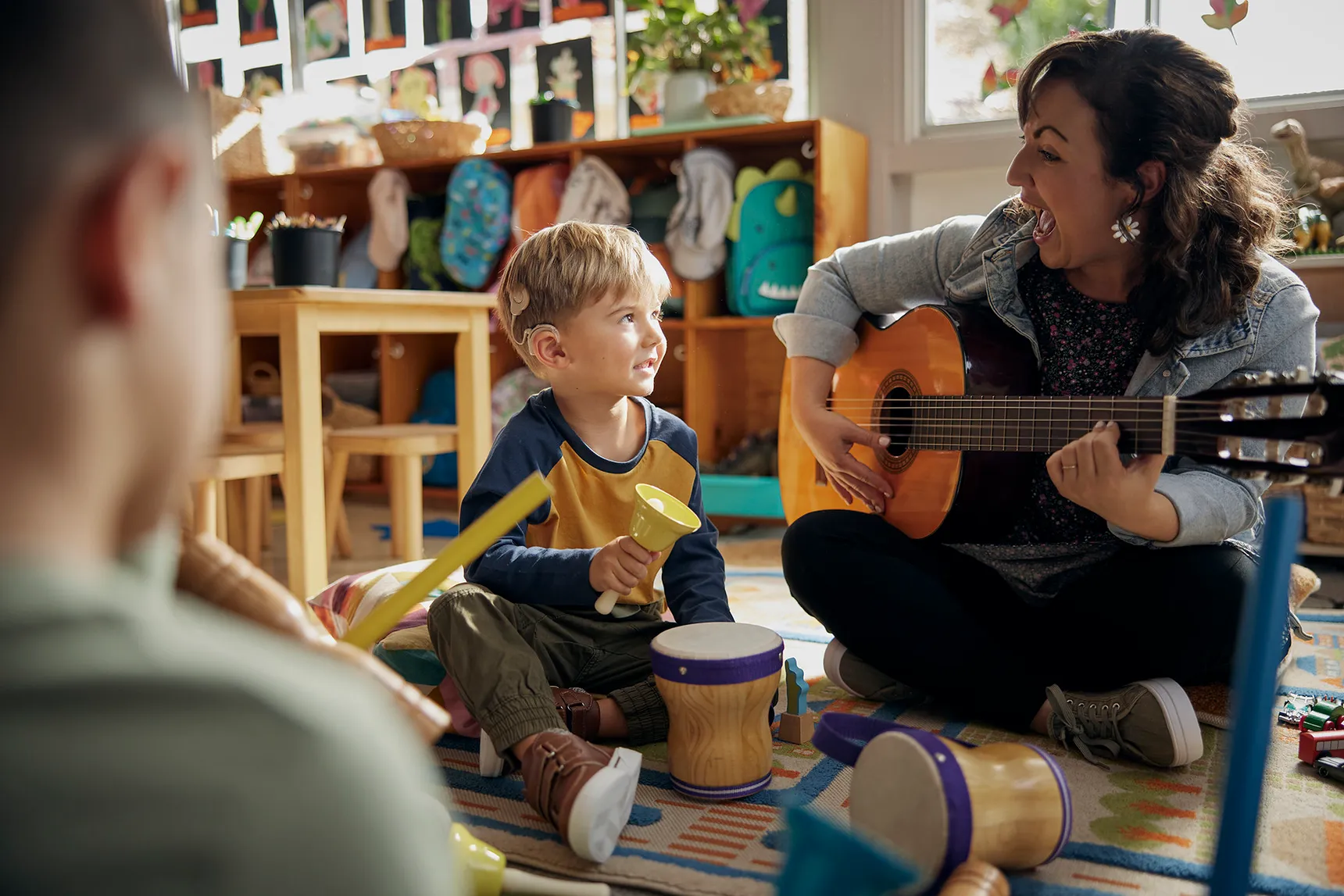 Dame qui joue de la guitare devant un enfant